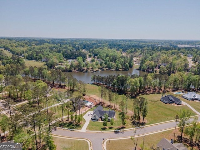 birds eye view of property featuring a wooded view and a water view