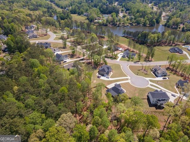 aerial view with a forest view and a water view