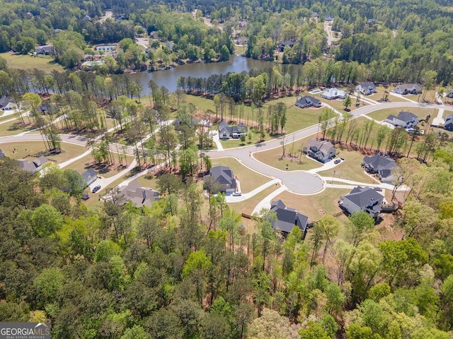 birds eye view of property with a water view, a residential view, and a view of trees