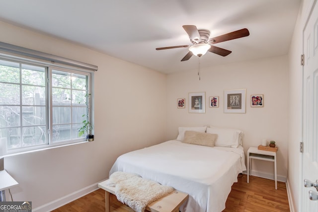 bedroom with baseboards, a ceiling fan, and wood finished floors