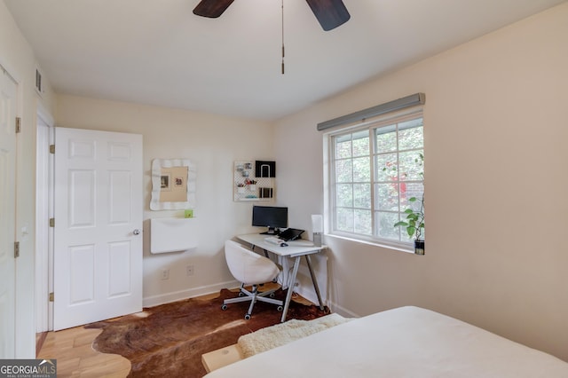 bedroom with baseboards, a ceiling fan, wood finished floors, and visible vents
