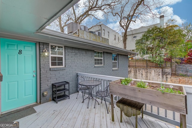wooden deck with a garden and fence