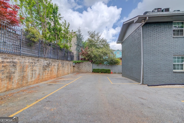 uncovered parking lot featuring fence