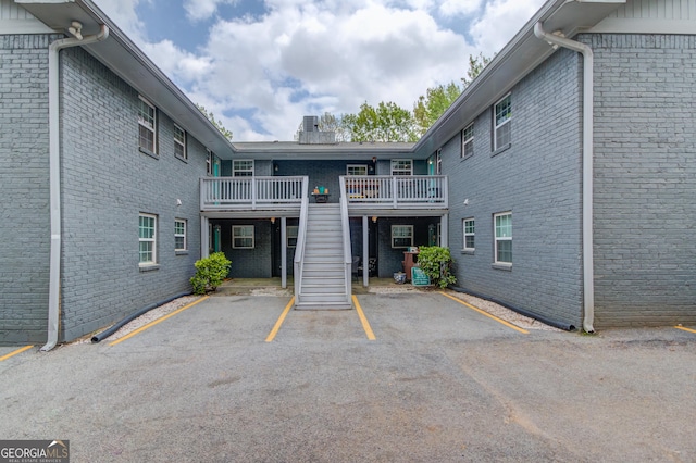 view of property with uncovered parking and stairway