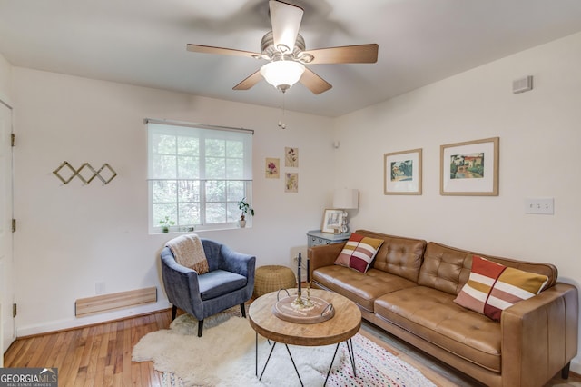 living area featuring baseboards, ceiling fan, and hardwood / wood-style floors