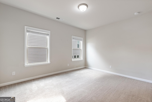 empty room with visible vents, baseboards, and carpet floors