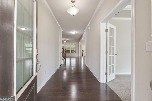 foyer entrance featuring crown molding, baseboards, and dark wood-style floors