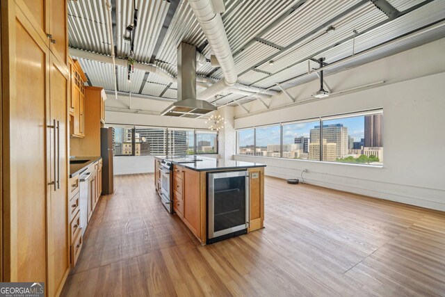 120 Ralph Mcgill Blvd NE Unit 1304 & 1305, Atlanta, GA 30308 - kitchen with wine cooler, stainless steel appliances, wood finished floors, a kitchen island with sink, and brown cabinets