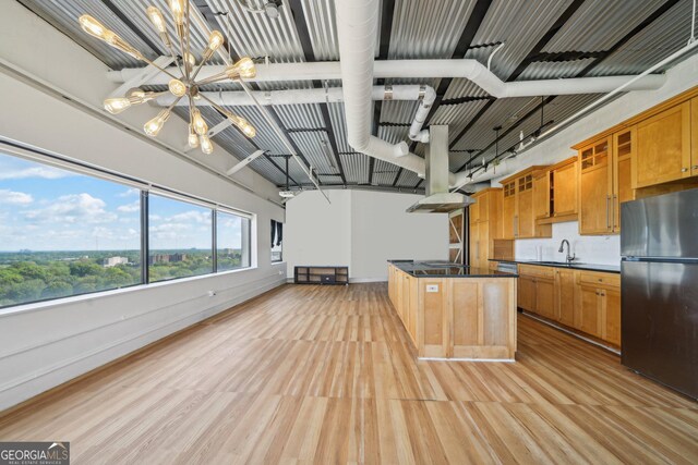 120 Ralph Mcgill Blvd NE Unit 1304 & 1305, Atlanta, GA 30308 - kitchen featuring freestanding refrigerator, a chandelier, dark countertops, light wood-style flooring, and glass insert cabinets