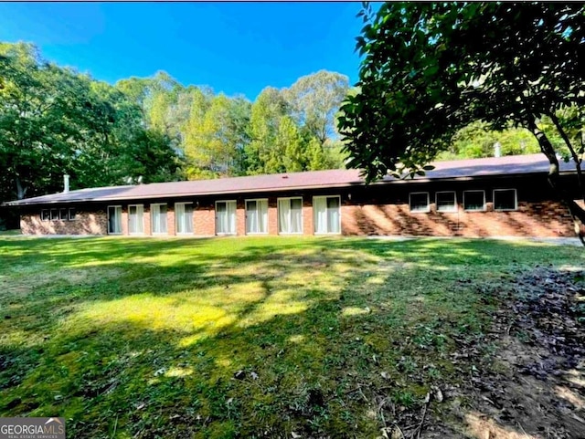 view of front of property featuring a front lawn and brick siding
