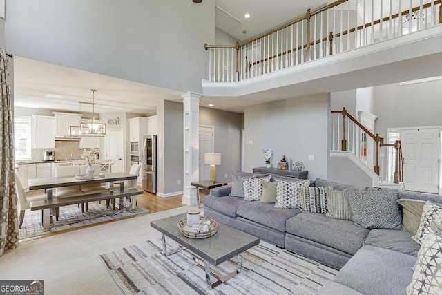 living room with baseboards, high vaulted ceiling, and stairs