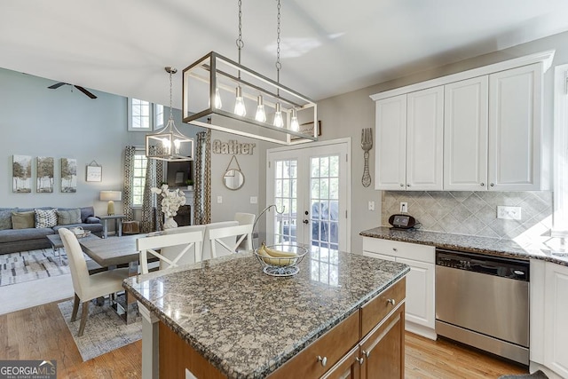 kitchen with french doors, stainless steel dishwasher, light wood-type flooring, and stone countertops
