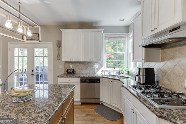 kitchen with gas stovetop, under cabinet range hood, dishwasher, a sink, and french doors