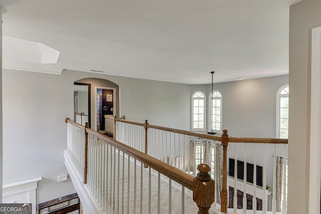 hallway with a wealth of natural light, an upstairs landing, visible vents, and a skylight