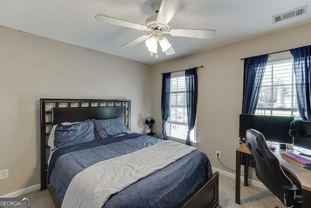carpeted bedroom with visible vents, baseboards, and ceiling fan