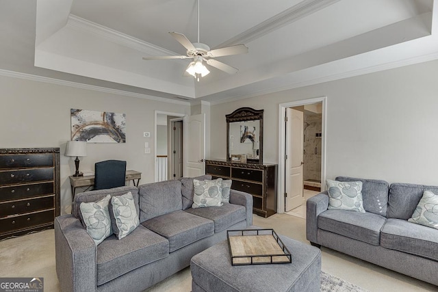 living area featuring light carpet, ceiling fan, ornamental molding, and a raised ceiling