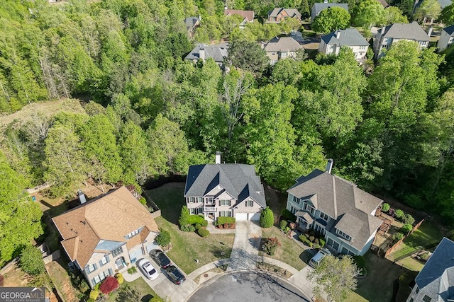drone / aerial view with a wooded view and a residential view
