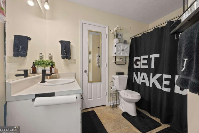 full bath featuring toilet, a textured ceiling, vanity, and curtained shower