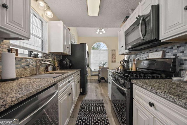 kitchen with decorative backsplash, gas range oven, dishwasher, and a sink