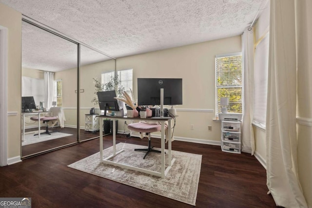 office area featuring baseboards, plenty of natural light, wood finished floors, and a textured ceiling