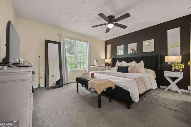 bedroom with baseboards, a ceiling fan, light carpet, and a textured ceiling