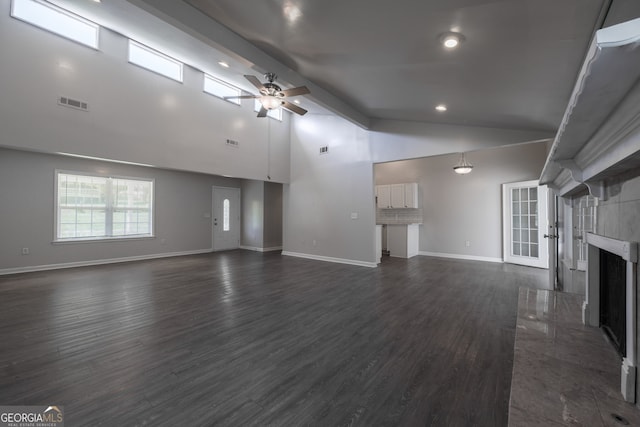 unfurnished living room featuring baseboards, visible vents, high vaulted ceiling, ceiling fan, and a fireplace