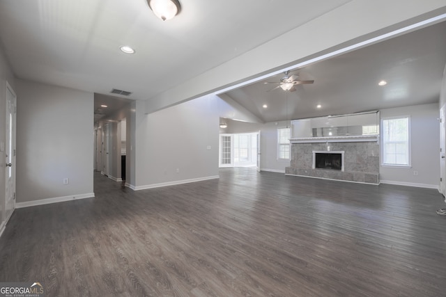 unfurnished living room featuring a tiled fireplace, plenty of natural light, visible vents, and ceiling fan