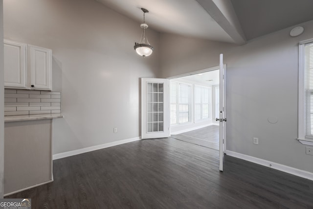 unfurnished dining area with french doors, baseboards, high vaulted ceiling, and dark wood-type flooring