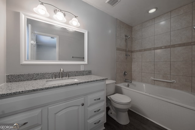 full bathroom with shower / washtub combination, wood finished floors, visible vents, toilet, and vanity