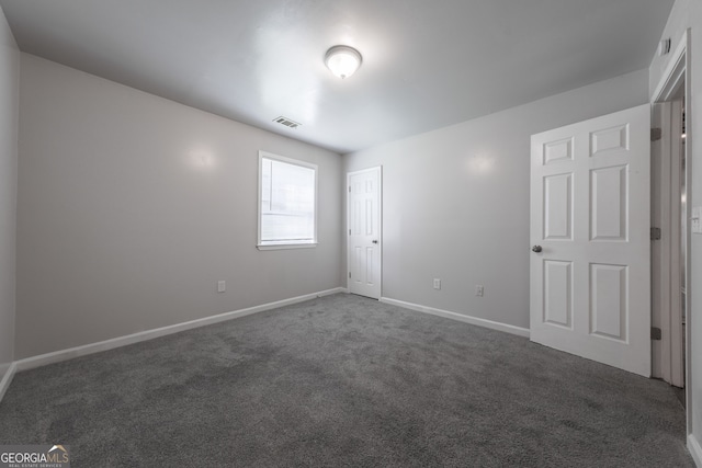 unfurnished bedroom featuring carpet, visible vents, and baseboards