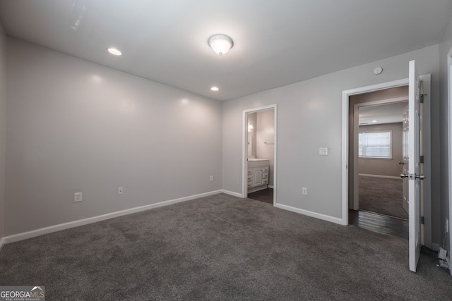 unfurnished bedroom with recessed lighting, dark carpet, baseboards, and connected bathroom