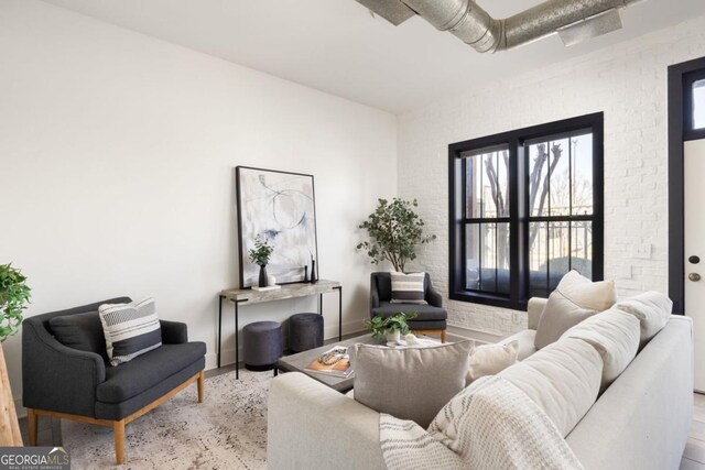 791 Wylie St SE Unit 105, Atlanta, GA 30316 - living area featuring baseboards, healthy amount of natural light, brick wall, and wood finished floors