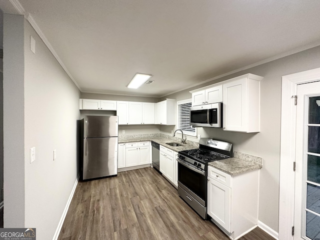 659 Country Club Rd, Newnan, GA 30263 - kitchen with wood finished floors, baseboards, ornamental molding, and stainless steel appliances