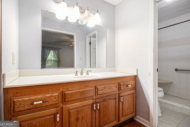 bathroom with vanity, toilet, and a tile shower