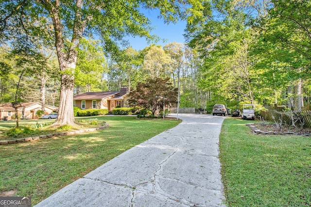 view of property's community featuring a lawn and driveway