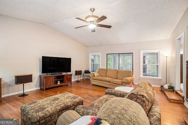 living area featuring wood finished floors, ceiling fan, and vaulted ceiling