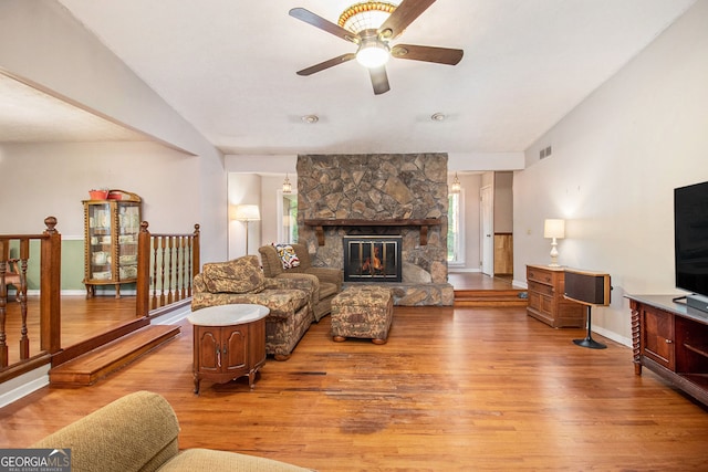 living area with visible vents, ceiling fan, baseboards, light wood finished floors, and vaulted ceiling