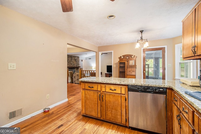 kitchen featuring visible vents, light wood-style floors, dishwasher, brown cabinetry, and ceiling fan with notable chandelier