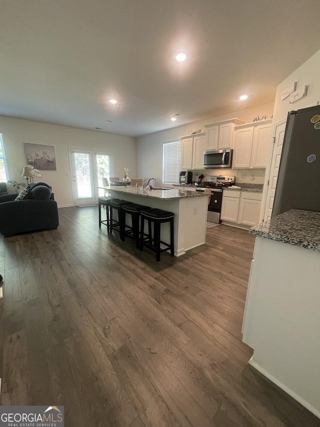 205 Sullivan St, Hampton, GA 30228 - kitchen with stainless steel appliances, dark wood-style flooring, white cabinets, light stone countertops, and recessed lighting