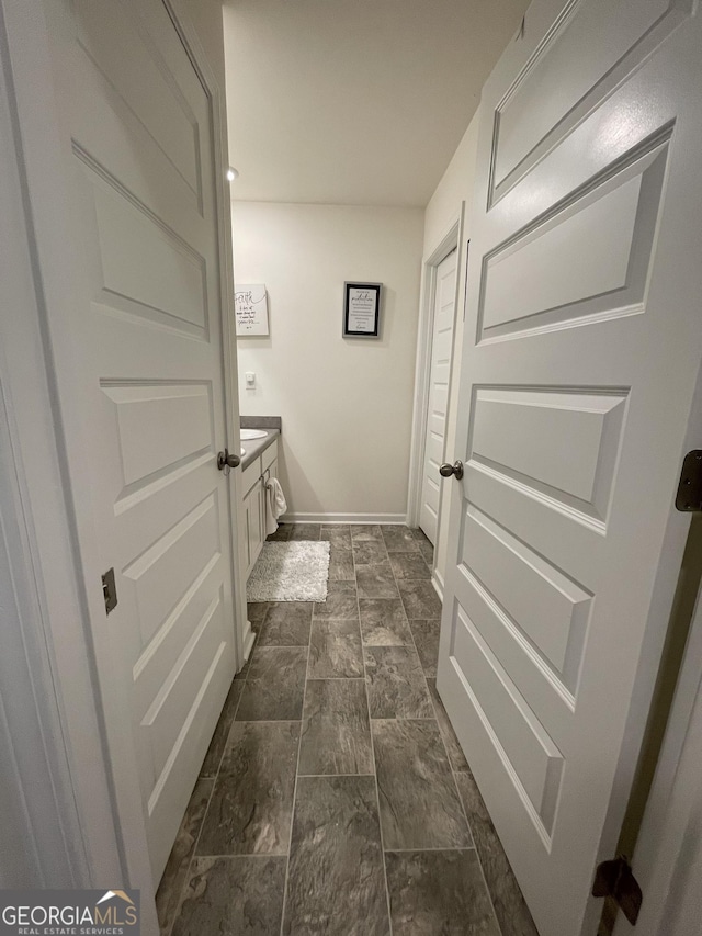 205 Sullivan St, Hampton, GA 30228 - bathroom with baseboards, vanity, and stone finish flooring
