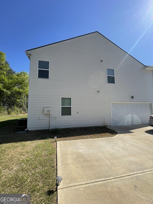 205 Sullivan St, Hampton, GA 30228 - view of side of home featuring a garage, a yard, and concrete driveway