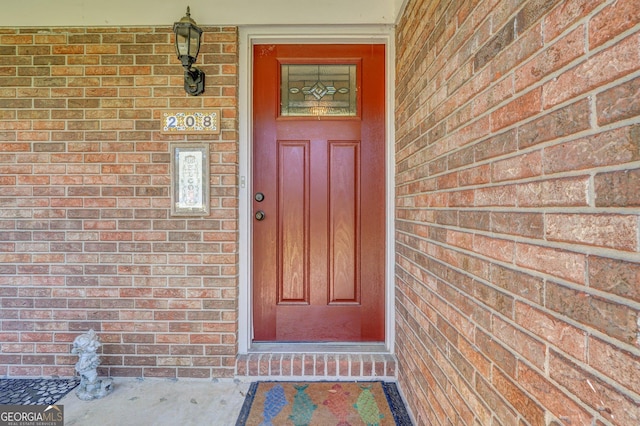 doorway to property with brick siding