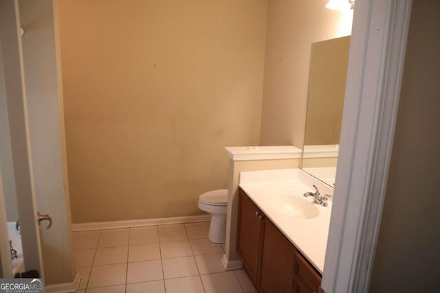 bathroom featuring toilet, vanity, baseboards, and tile patterned flooring
