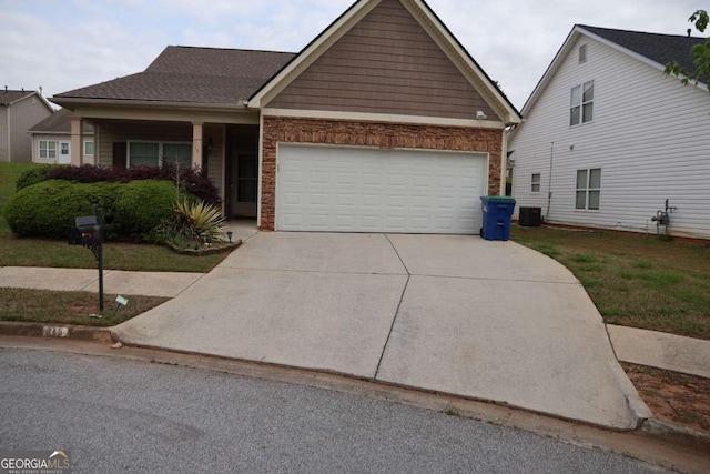 view of front of house with an attached garage, driveway, and central AC unit