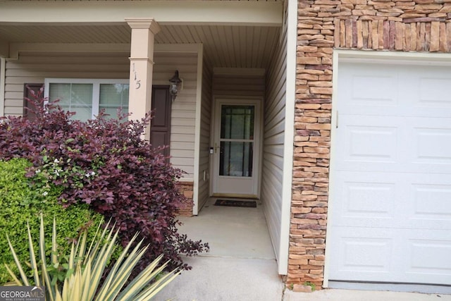 doorway to property featuring covered porch and stone siding