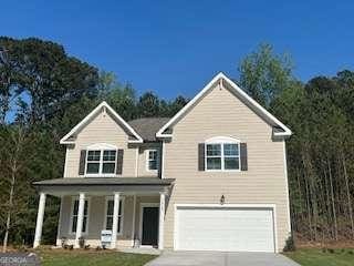 traditional home featuring driveway, a garage, and covered porch