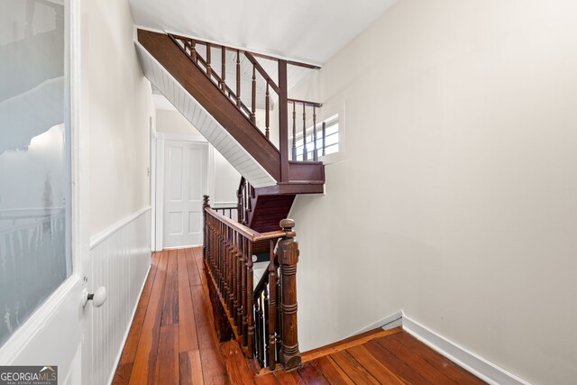 stairway featuring baseboards and hardwood / wood-style flooring