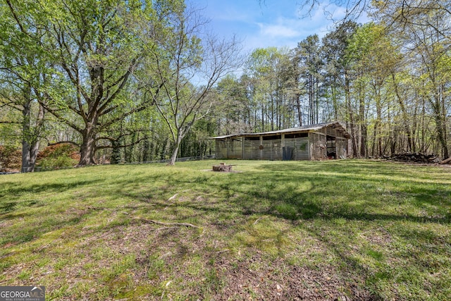 view of yard with an outdoor structure, fence, and an outbuilding