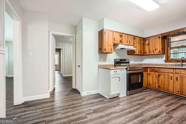 1105 S Parkwood Dr, Forest Park, GA 30297 - kitchen with dark wood-type flooring, under cabinet range hood, stainless steel range with electric cooktop, and light countertops