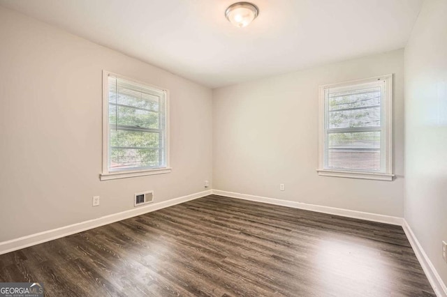 1105 S Parkwood Dr, Forest Park, GA 30297 - unfurnished room featuring plenty of natural light, visible vents, baseboards, and dark wood-style floors